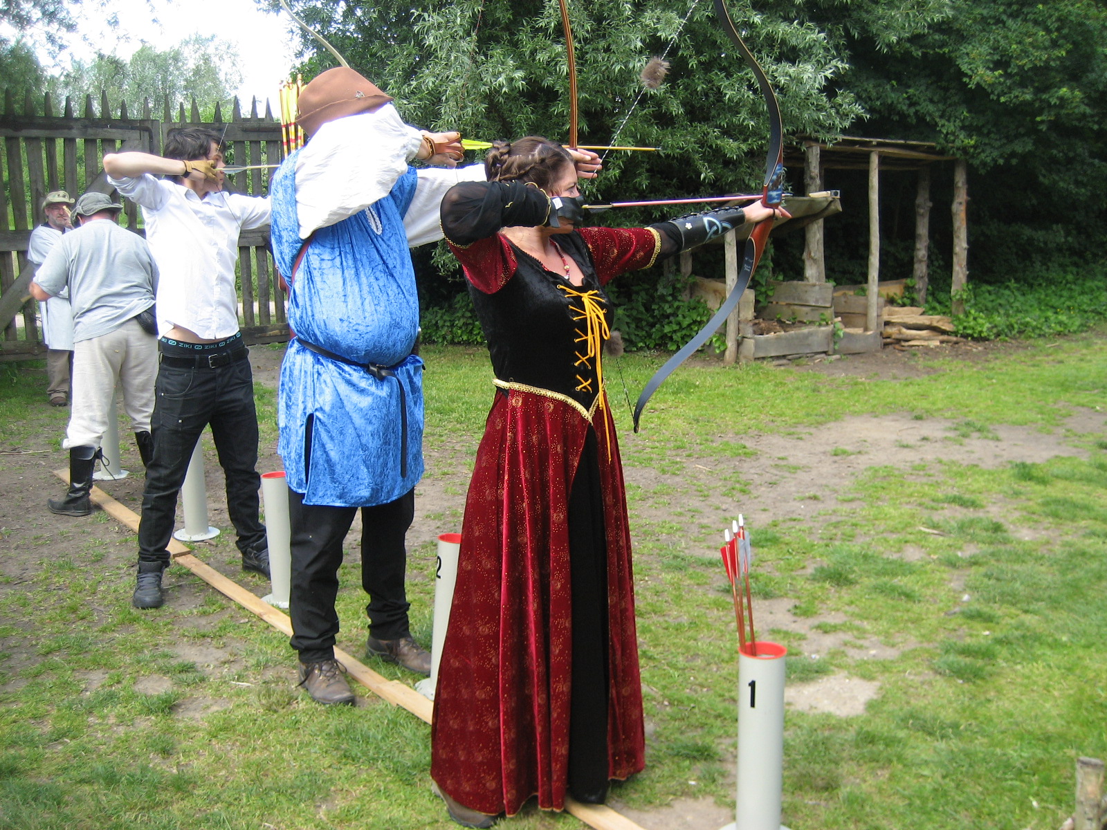 In middeleeuwse kledij op de schietlijn van een handboogwedstrijd in het prehistorisch dorp in Eindhoven